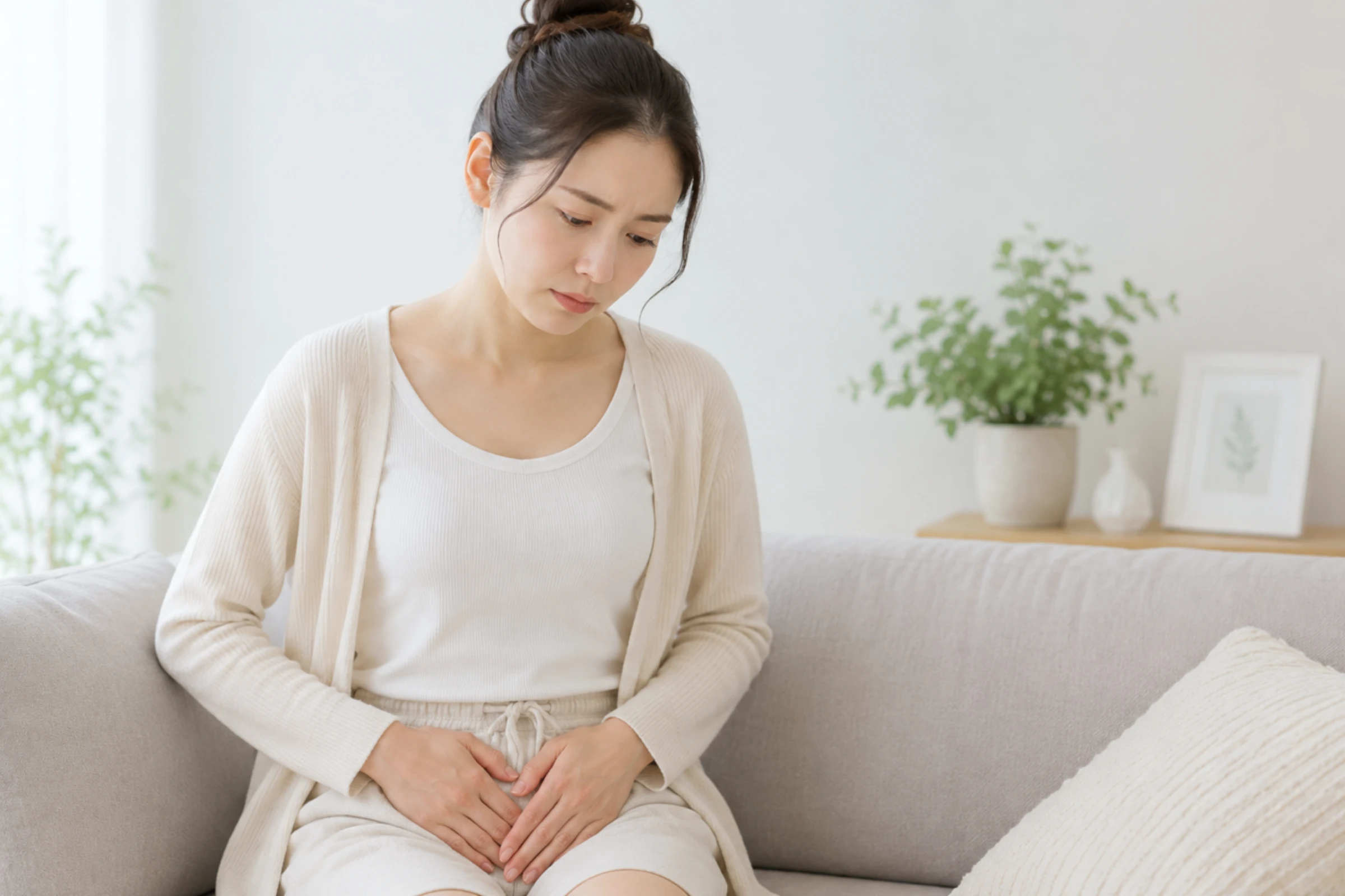 お腹に手を当てる女性