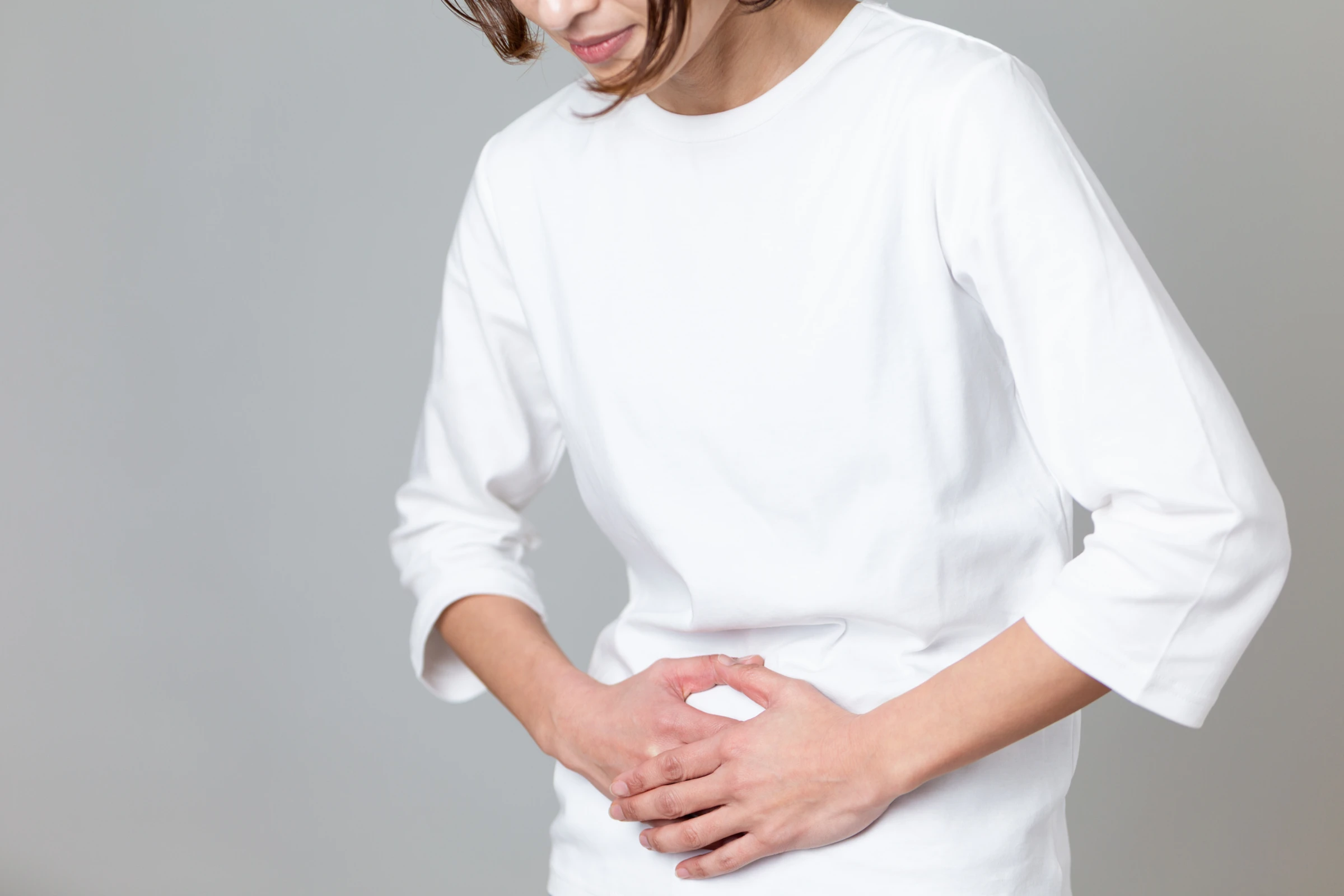 お腹を抱える女性