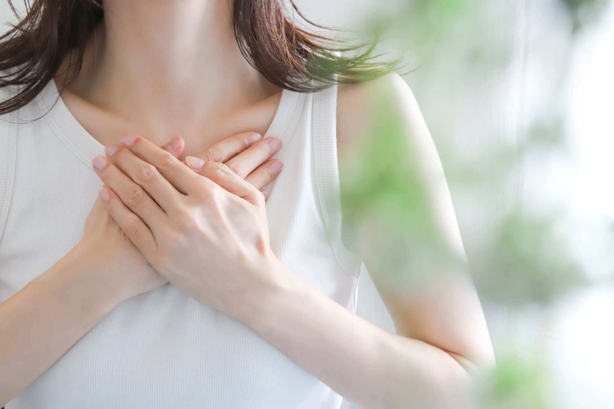 胸に手を当てる女性
