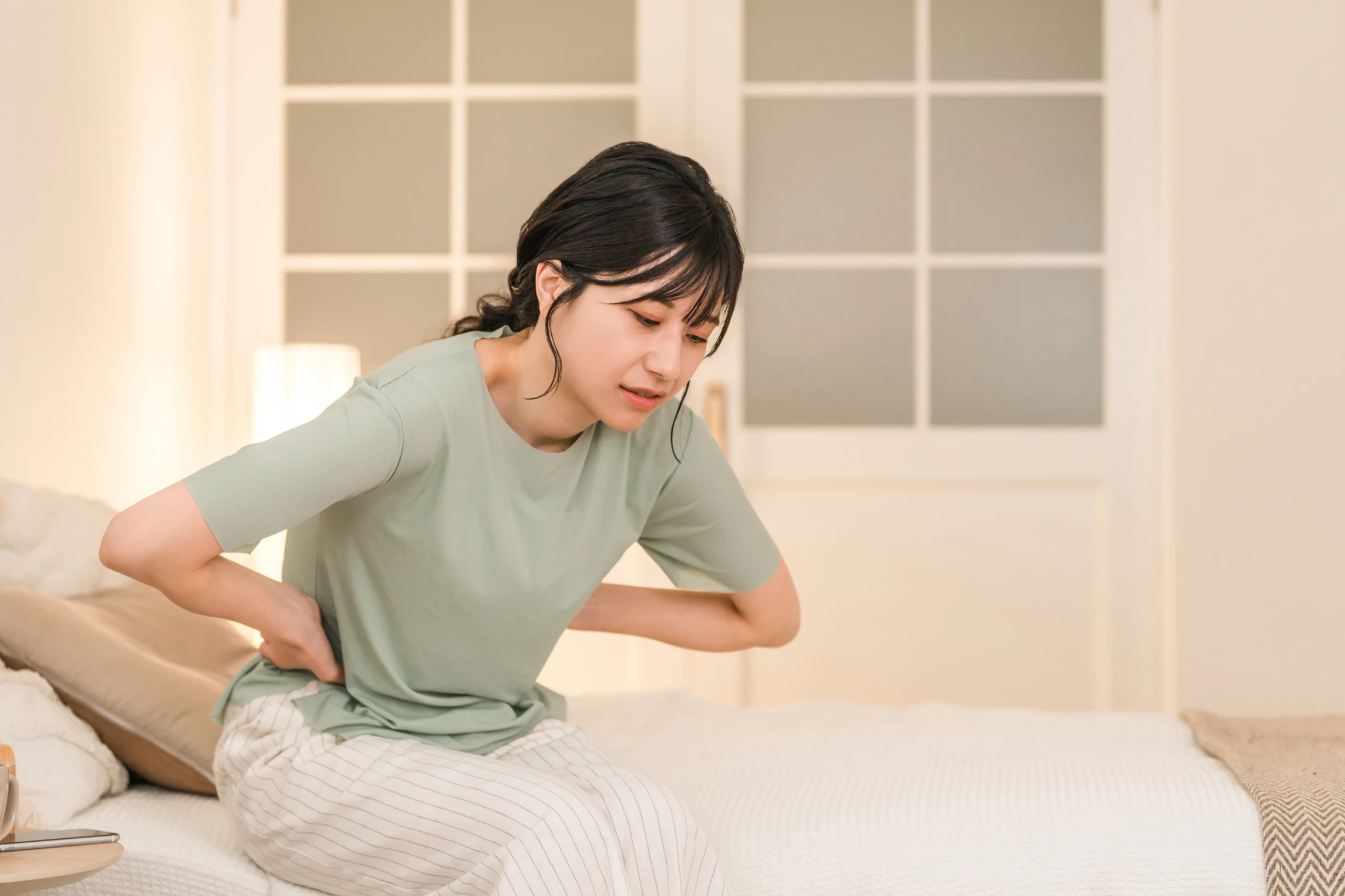 脇腹を押さえて苦しそうな女性
