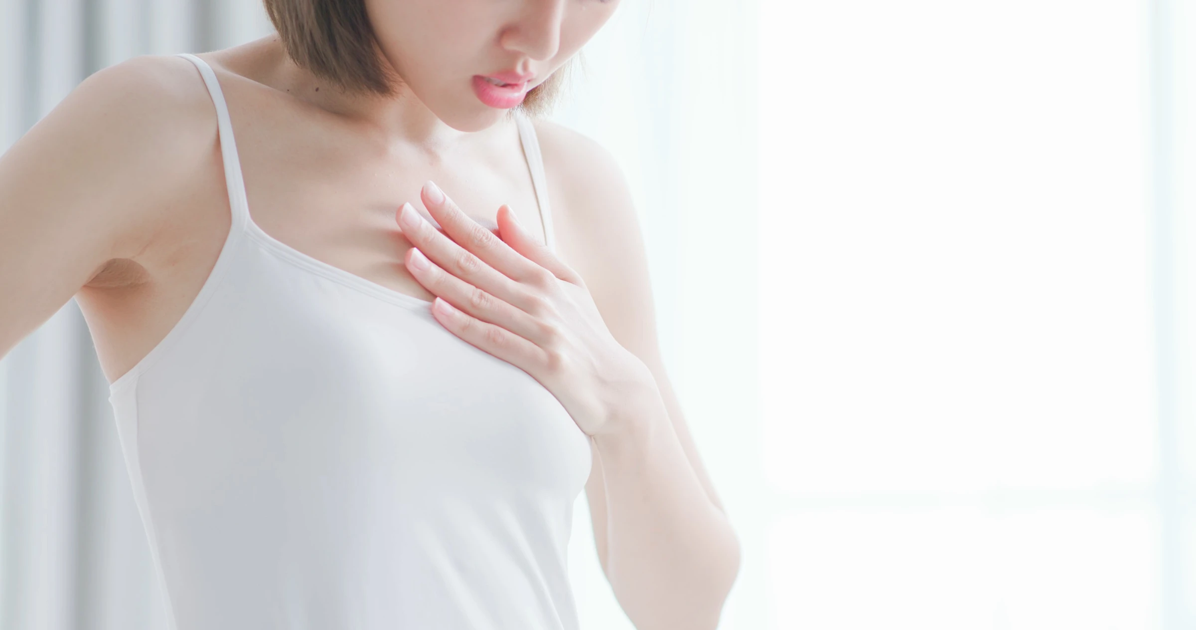 胸を押さえる女性